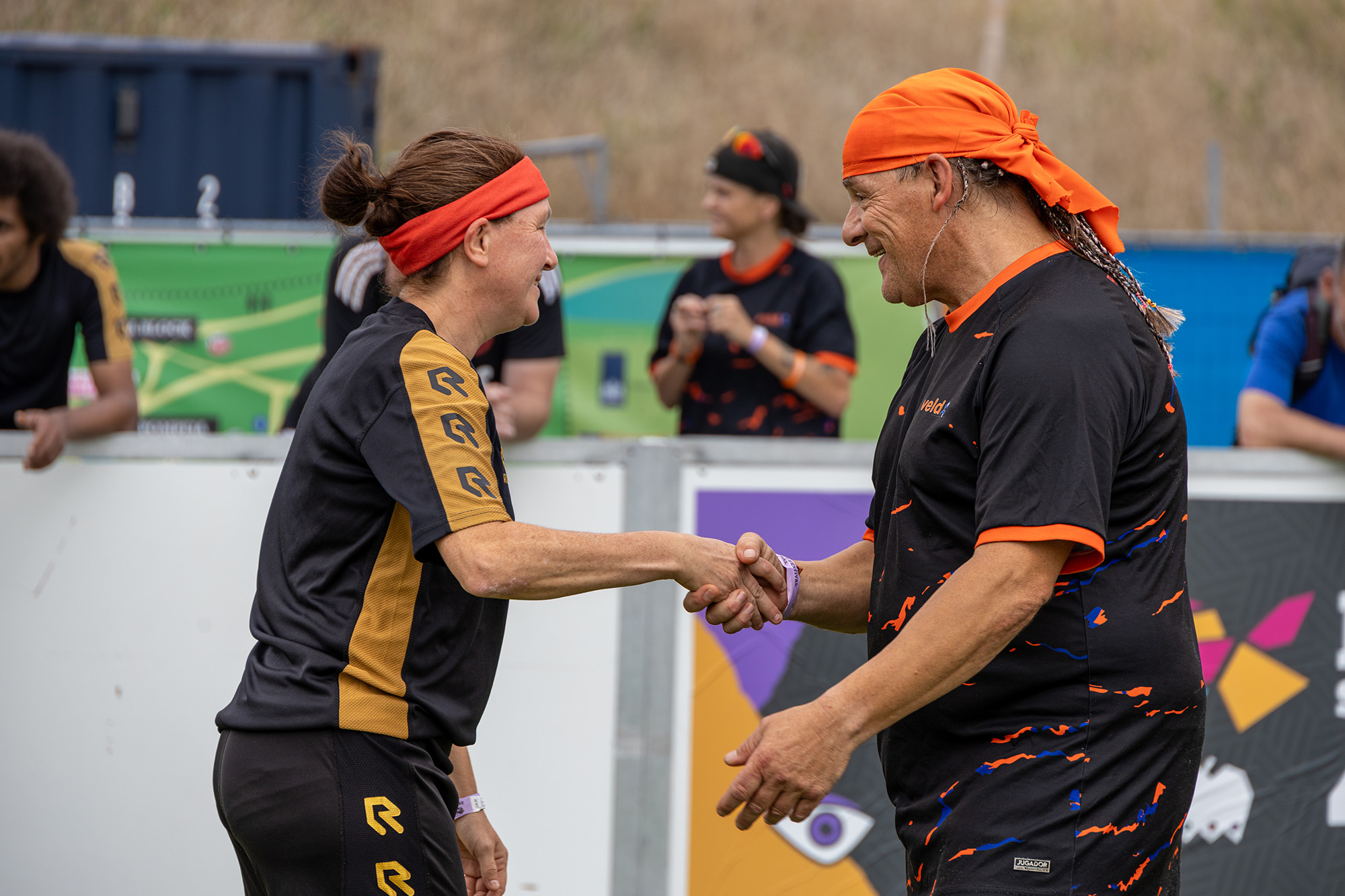 twee sporters geven elkaar de hand op een voetbalveld