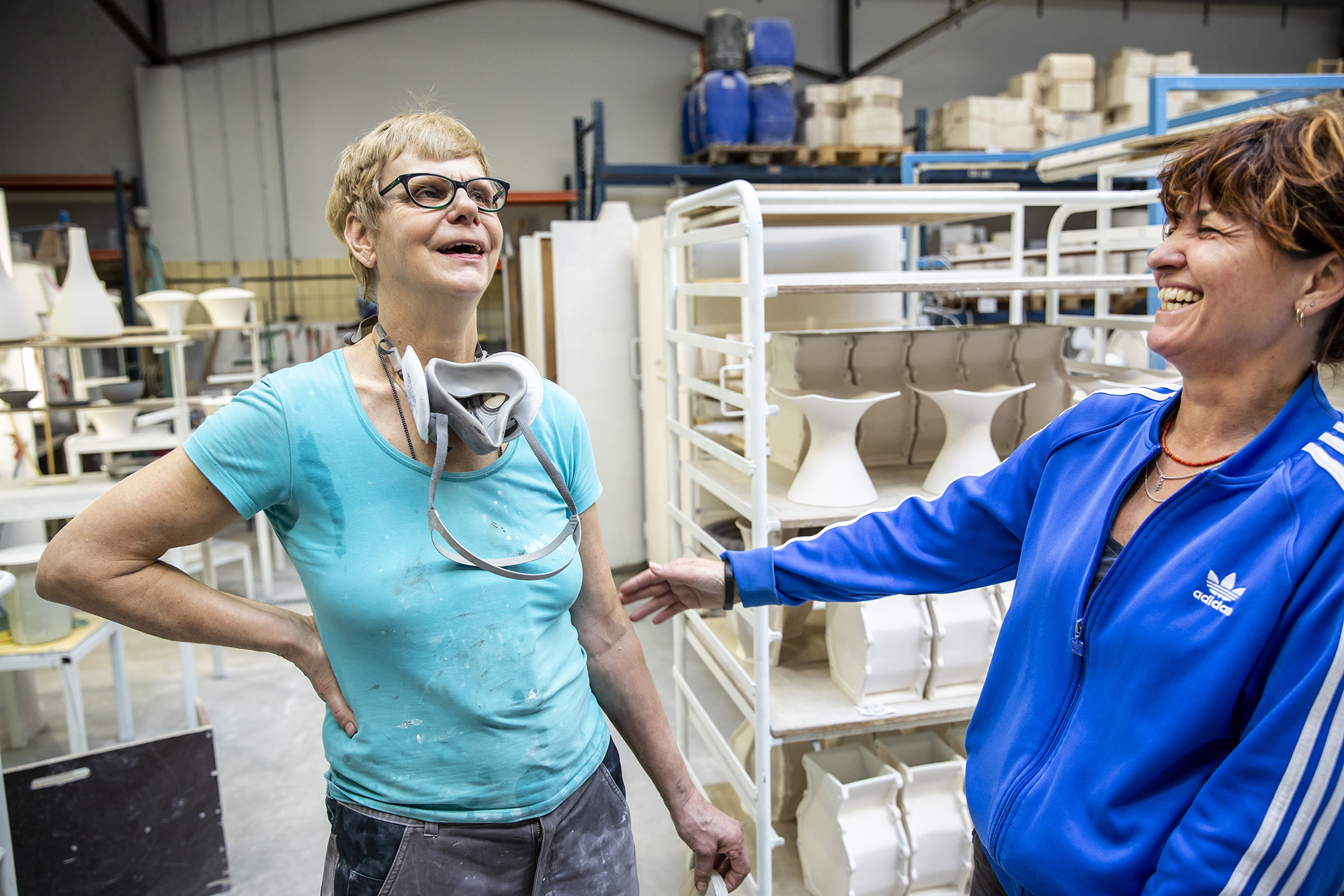 Twee vrouwen lachen samen in een keramiekatelier