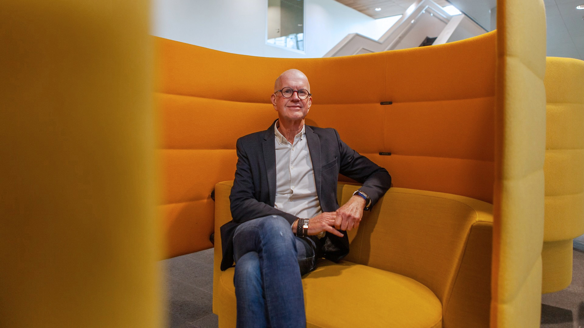 man in een grote oranje stoel