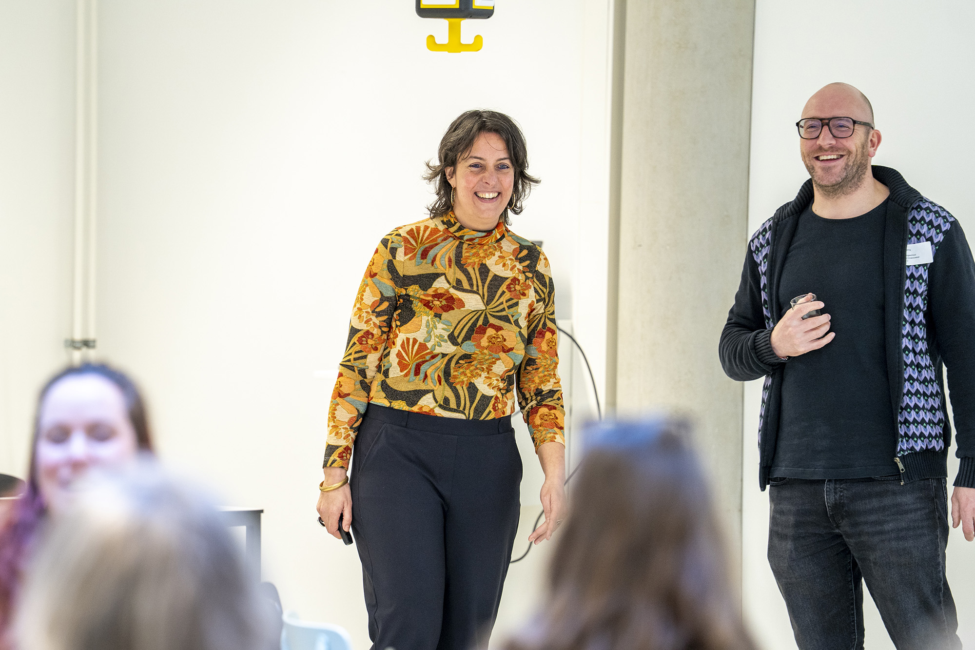 vrouw en man beantwoorden vragen van publiek tijdens een evenement