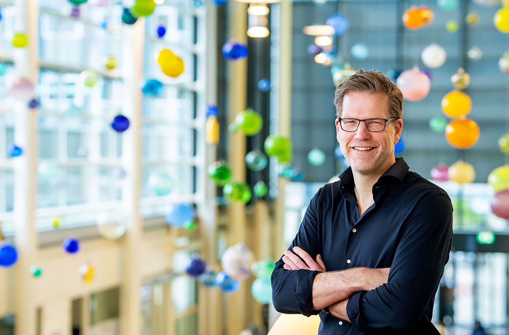 hoogleraar experimentele genetica tegen een achtergrond van gekleurde glazen bollen